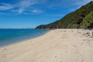 Serene Beach with Clear Water and Green Hills