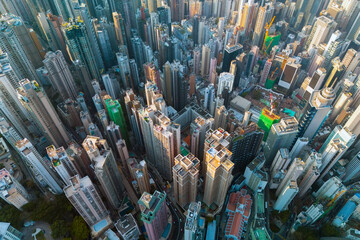Top down perspective over Hong Kong reveals the incredible density of its high-rise buildings. Sunlight streams through the towers, highlighting the vibrant architecture and busy city life