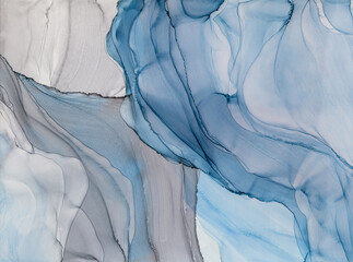 Fluid motion of blue and gray alcohol ink art on a textured surface