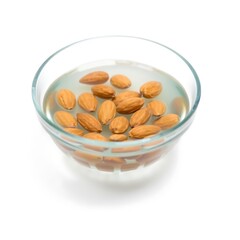 Whole raw almonds soaking in clear water in a glass bowl