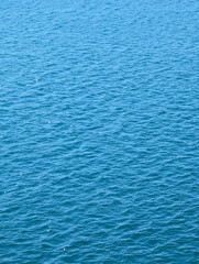 Fototapeta premium Vast, tranquil blue ocean surface with gentle ripples and waves, creating a beautiful and serene natural background or texture.