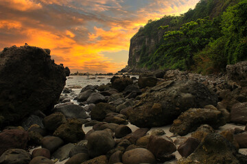 Rocky shoreline with a sunset beach and mountain view