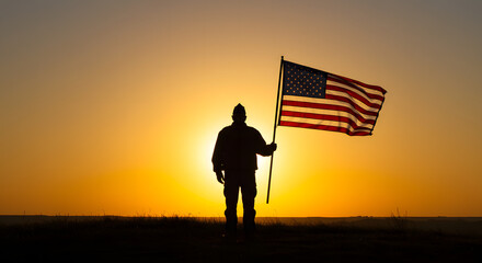 Silhouette of a soldier holding the American flag against a vibrant sunset, symbolizing patriotism, service, and remembrance.