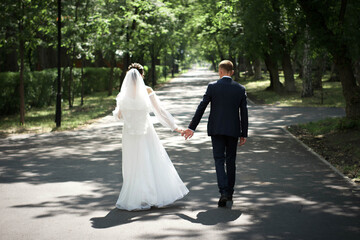 Newlyweds Holding Hands on a Summer Park Walk