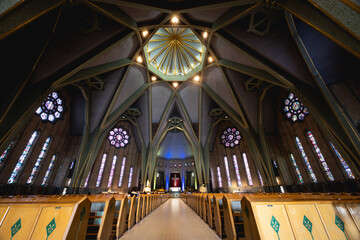 Interior view of basilica with arches, pews, and soft lighting.
