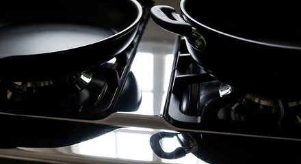 Close up of two black cooking pans on a gas stove, ready for culinary preparation