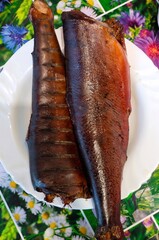 Smoked fish on a plate with floral background and vivid colors