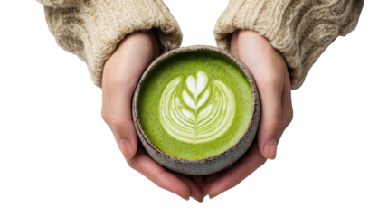 Hands holding a bowl of green matcha latte with decorative leaf pattern, over white isolated background.