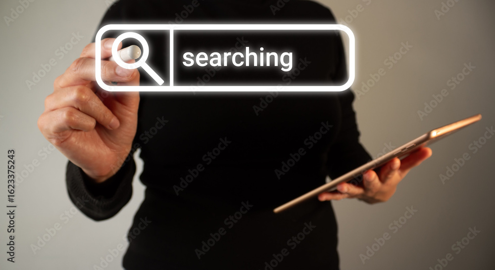 Poster person holding a tablet while pointing at a web search bar
