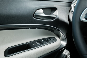 Car Interior Detail: Door Panel Window Controls and Handle - Sleek Automotive Design with Textured...