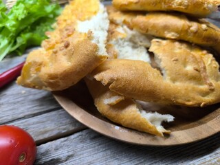 aked pieces of flat bread with cheese on a wooden plate