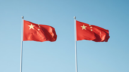 Two red flags with yellow stars against a clear blue sky, evoking patriotism and national identity.