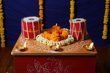 Indian traditional musical instruments tabla and offerings of flowers and diyas arranged for a religious puja ceremony during a festival