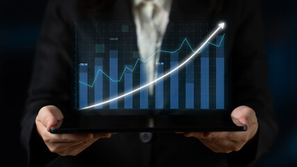 A businesswoman presents a tablet displaying a digital graph that illustrates financial growth, symbolizing success and innovation in the corporate world. Impute
