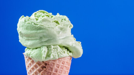 A refreshing scoop of matcha green tea ice cream with blue background