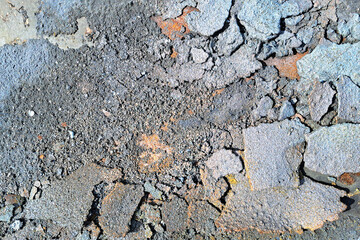Cracked asphalt surface background. Damaged concrete pavement texture with loose debris. Broken rough street material. Urban infrastructure problem. Construction detail. Erosion and decay concept.