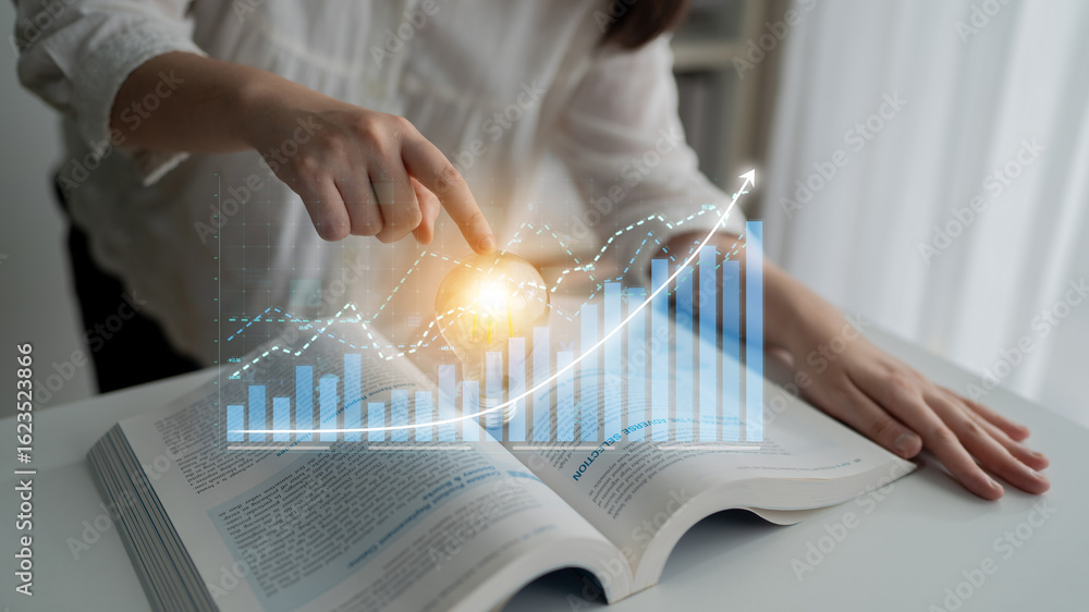 Poster a person engaged in financial analysis by pointing at an open book while a digital chart overlay dis