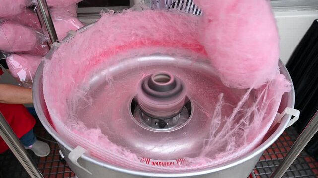 Street vendor making pink cotton candy in machine