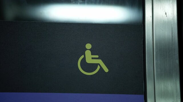 Close-up of accessibility stickers indicating designated places for people with disabilities in public locations. Universal accessibility symbols on walls or seats.