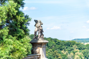 Obraz premium A headless ancient statue stands on a stone pedestal with intricate carvings.