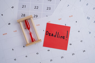 Hourglass and calendar on the table. Deadline. Concept of important time and deadlines