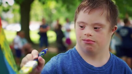 Joyful Expression Boy with Down Syndrome Painting Outdoors in Vibrant Colors.