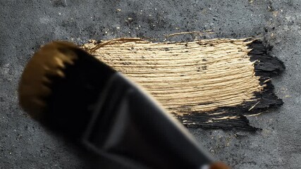 Close Up of Black and Gold Paintbrush Stroke on Dark Gray Textured Surface: A Detailed Visual of Artistic Application with Metallic Accents, Showing - Powered by Adobe