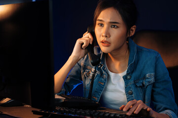 Young beautiful Asian creative woman calling on phone desk to customer or coworker explaining...