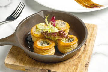 Herb Butter Baked Snail Puff Pastry box iron skillet on wooden board side view of French Appetizer
