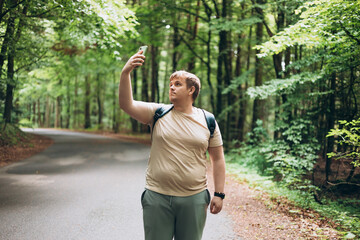 Sad blonde man got lost and could not find an internet connection on phone while hiking alone in...