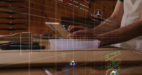 Operating adult male technician using tablet on wooden workbench with metal tools, with AR charts