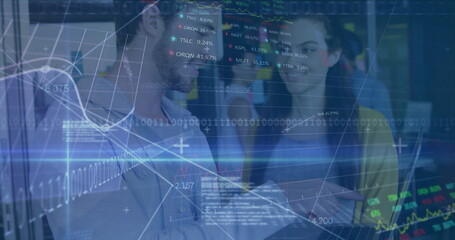 Collaborating data professionals examining laptop in modern office, with financial charts overlay