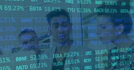 Reviewing analyst team examining scrolling tickers on glass wall in office, with binders