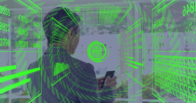 Examining data panels businesswoman in blazer holding smartphone in modern office, green holograms