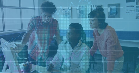 Analyzing data on monitor by colleagues wearing sweater, plaid shirt and hoodie in modern workspace