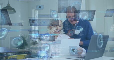 Reviewing senior couple examining document at home office, with digital overlays laptop eyeglasses