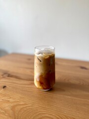Iced coffee in a transparent glass with ice and milk
