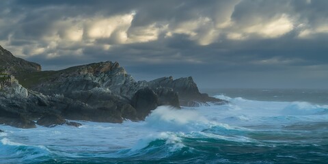 Obraz premium Crashing waves against rugged grey cliffs under dramatic cloudy sky ocean spray