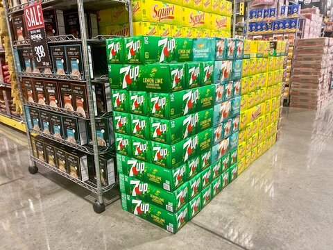 Pile 9f Carton boxes of made in USA Seven up 7up brand cans of carbonated sweetened soda for sale at a local California supermarket