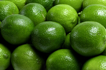 Background of bright green limes. Freshness, juiciness and natural texture of citrus fruits