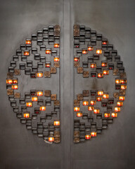 Candles in Symmetrical Wall Art on a Dark, Textured Surface