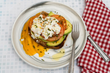 Delicious guacamole toast with poached egg topping