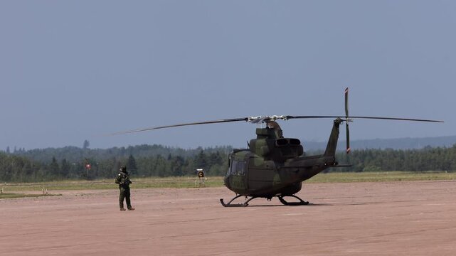 Summerside Prince Edward Island Canada - July 15th 2025 - Canadian Armed Forces CH-146 Griffon Helicopter Pilot begins pre flight checks - wide shot
