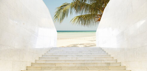  Staircase leading to a beautiful beach with palm trees and ocean view on a sunny day.