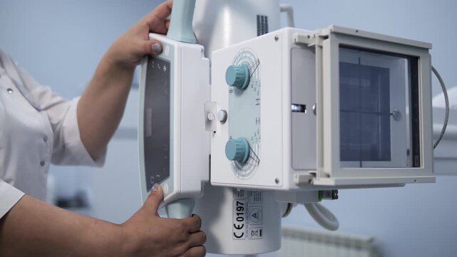 Radiology technician operating hospital X-ray equipment