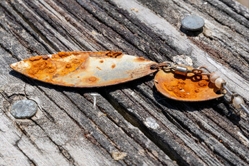 Rusty lure lying on wood rail next to lake