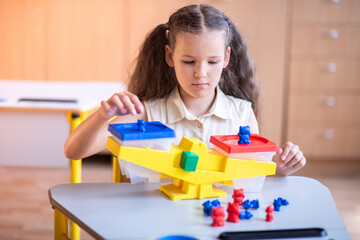 Engaging First Grader Discovers Balance and Counting While Playing With Colorful Bears During a...