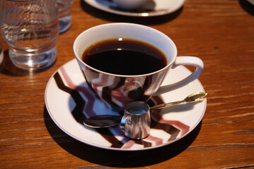 木製カウンターに並ぶホットコーヒーの一杯