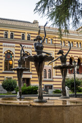 Fototapeta premium Bronze ballerinas gracefully pose in a fountain outside Tbilisi Opera and Ballet Theatre reflecting the city's rich culture and arts heritage.
