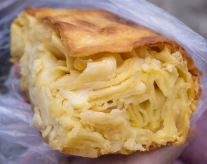 A close-up on Achma Khachapuri, cheesy bread, in a bag. This savory pastry is a staple in Georgia...